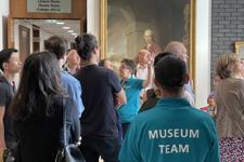 A Tour Group Listenign To A Guide At The RCP