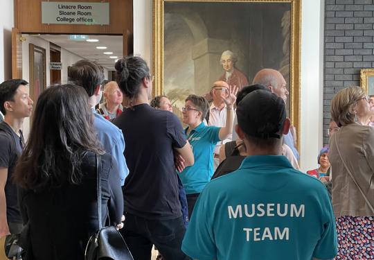 A Tour Group Listenign To A Guide At The RCP