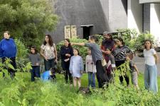 A group of families being shown the garden by a gardener