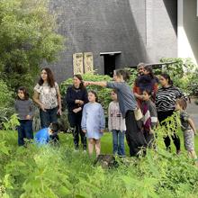 A group of families being shown the garden by a gardener